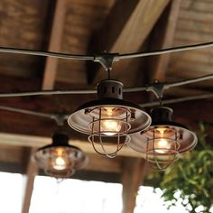 three lights are hanging from the ceiling in an outdoor area with wood beams and exposed rafters