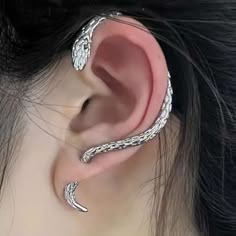 a woman wearing an ear cuff with two silver snakes on the top of her ear