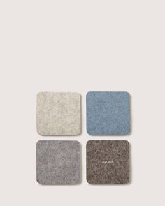 four square coasters in various colors and sizes on a gray background with the word,