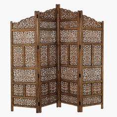 a wooden screen with intricate carvings on the top and bottom panel, set against a white background