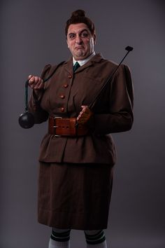 a man dressed in an old - fashioned uniform holding a golf club and wearing socks