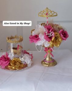 two vases filled with flowers on top of a white table cloth covered tablecloth