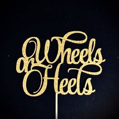 there is a cake topper that says wheels and heels in gold glitter on a black background