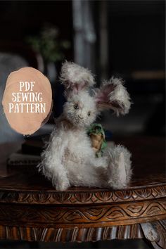 a white stuffed animal sitting on top of a wooden table