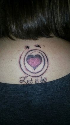 a woman with a heart tattoo on her neck and the words let it be written in cursive writing