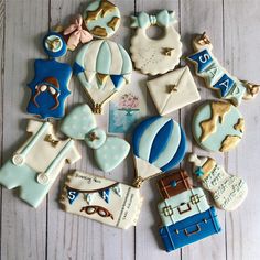 decorated cookies are arranged on a white table with blue trimmings and gold accents