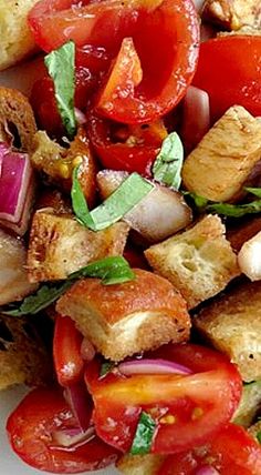 a white plate topped with tofu, tomatoes and other vegtables on top of it