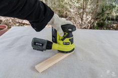 a person using a sander on top of a table