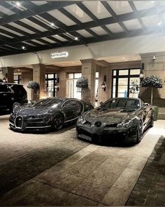 two black sports cars parked in front of a building