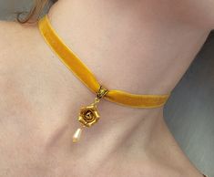 Yellow-gold Velvet ribbon with gold rose and drop. Size of rose 15-18 mm across. Gold plated findings- bail, clasps, lobster claw.  If you want to change color for the clasps please leave the note by checkout. Velvet ribbon choker with sculpted flower. Material of rose is polymer clay. Each petal of flower made by hand Dia flower about 15 mm/ 0.55 " Length of necklace is adjustable: 10-12 inches/ 25,4 - 30,5 cm 11-13 inches/ 28-33 cm 12-14 inches/ 30.5- 35.5 cm 13-15 inches/ 33-38 cm 14-16 inche Elegant Yellow Choker As A Gift, Elegant Yellow Choker For Gifts, Adjustable Gold Rose Design Jewelry, Gold Flower Choker As Gift, Gold Choker With Flower Charm, Rose Choker, Ribbon Choker, Ribbon Necklace, Floral Jewelry