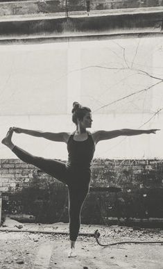 a woman in a black leotard doing a yoga pose