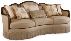 a couch with many pillows on it and fringe trimming around the armrests