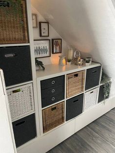 a room with many baskets and pictures on the wall, including an open bookcase