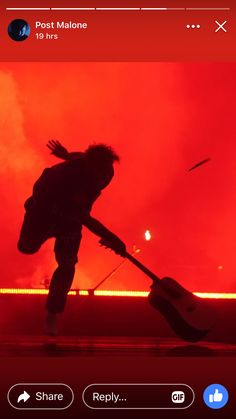 the silhouette of a person holding a guitar in front of a red sky