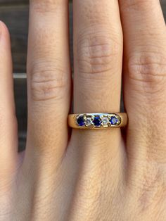 a woman's hand with a three stone ring on top of her finger,