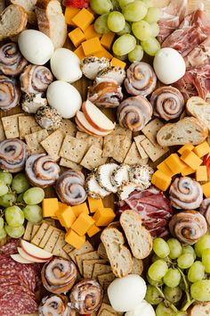 an assortment of cheeses, meats and crackers on a platter