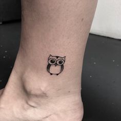 an owl tattoo on the ankle that is black and white, with a small eye