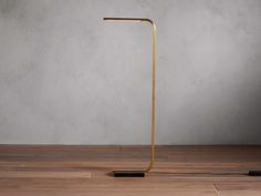 a gold floor lamp on a wooden floor