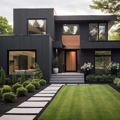 a modern house with grass and trees in the front yard