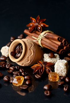 coffee beans, cinnamon sticks and star anise on a black surface with other ingredients