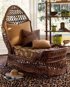 a wicker chair sitting on top of a leopard print rug in front of a window