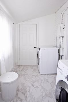 a washer and dryer in a white room with marble flooring on the walls