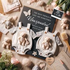 two teddy bears in overalls on top of a table with flowers and other items