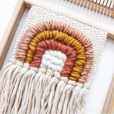 a close up of a weaving machine with yarn on the side and a piece of wood next to it