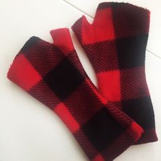 two red and black checkered mittens sitting on top of a white table next to each other