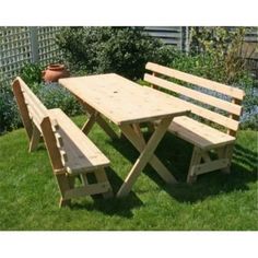 a wooden picnic table and benches in the grass