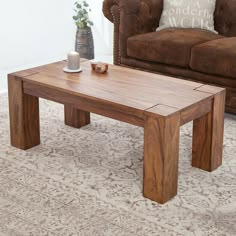 a wooden coffee table sitting on top of a carpeted floor next to a couch