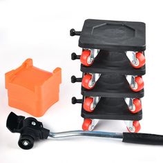 an orange and black toy truck with wheels on it's side, next to a tool