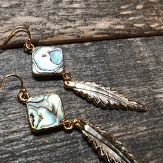 Who doesn't love a little shimmer in their life? Answer the siren's song and get a pair of these beauties for yourself or someone you love. Hand carved abalone feathers dangle from super iridescent abalone squares. The color in these is just amazing and my photos just can't seem to capture it. The perfect earrings to wear with jeans and a t-shirt, at the beach, or on vacation. High quality gold fill ear wires. Length : 3" Listing is for one pair. All of these are made from natural abalone shells Iridescent Mother Of Pearl Jewelry With Matching Earrings, Iridescent Mother Of Pearl Dangle Jewelry, Abalone Shell Jewelry For Pierced Ears As Gift, Gold Abalone Shell Earrings For Gifts, Adjustable Dangle Feather Jewelry, Dangle Feather Jewelry As A Gift, Feathered Dangle Jewelry As A Gift, Iridescent Abalone Shell Dangle Earrings, Iridescent Dangle Earrings From Abalone Shell