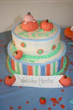 a three tiered cake with pumpkins on the top and welcome hunter sign below