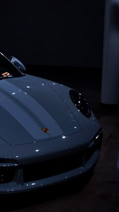 a blue sports car parked in a dark room