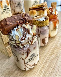 there are many desserts in the jars on the table with ice cream and chocolate