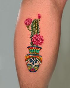 a tattoo on the leg of a man with a potted plant painted on it