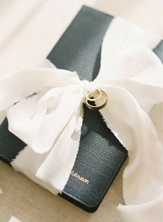 a black and white book with a ring tied to it