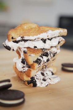 three cookies and cream sandwiches stacked on top of each other with oreo slices around them