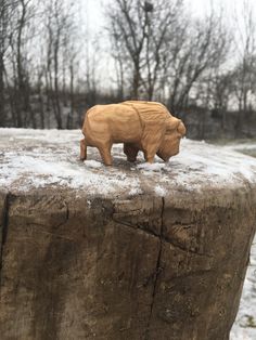 a small wooden bear on top of a rock