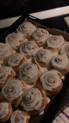 a pan filled with cinnamon rolls covered in icing