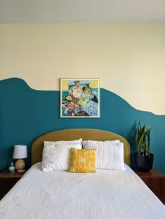 a bed with white sheets and pillows in front of a painting on the wall above it