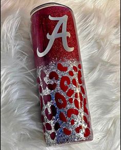 a red and white can with the letter a on it sitting on a furry surface