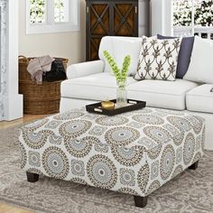 a living room filled with furniture and a coffee table on top of a rug in front of a fireplace