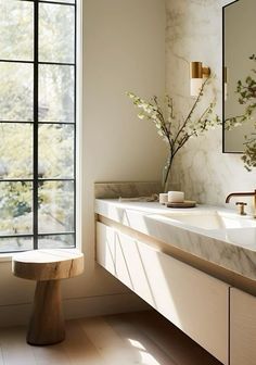 a bathroom with marble counter tops and two sinks in front of a large window that looks out onto the trees outside