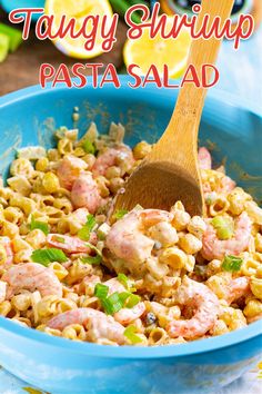 a blue bowl filled with pasta salad and a wooden spatula in the bottom left corner