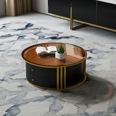 a coffee table with an open book and plant on it in a room that has carpeted flooring