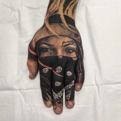 a woman's hand with tattoos on it and her face painted onto the palm