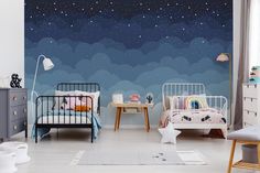 a child's room with two beds and a night sky mural