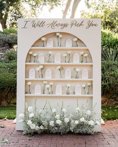 a white book shelf with flowers and candles on it that says i will always pick you